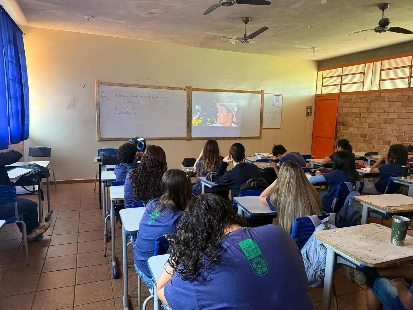 Alunos assistindo a um filme em sala de aula